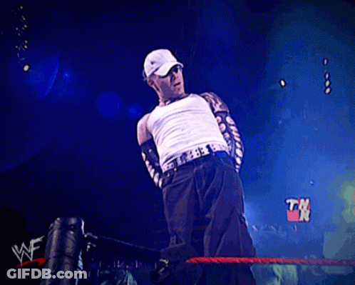 Man In White Tank Top In Wrestling Ring With TNT Sign GIF