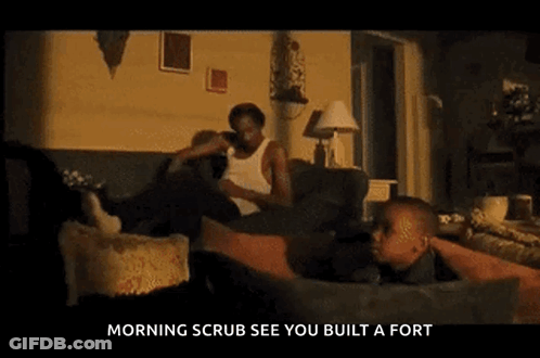 Man In White Tank Top Looking At Camera GIF