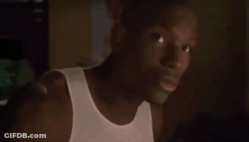 Man In White Tank Top Looking At Camera GIF