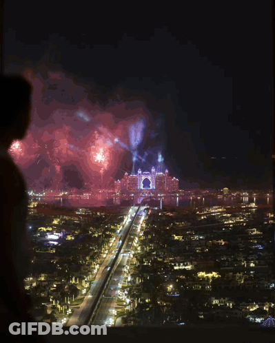 Man In White Tank Top Looking Over City At Night GIF