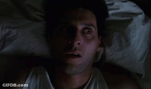 Man In White Tank Top Lying In Bed Eyes Closed GIF