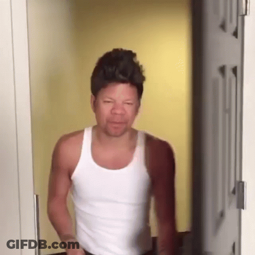 Man In White Tank Top Making Funny Face In Doorway GIF