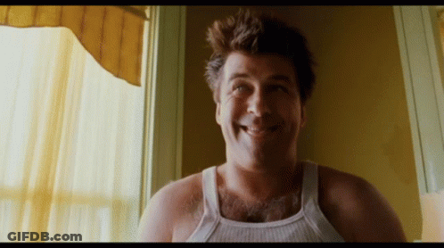 Man In White Tank Top Smiling Out Window GIF