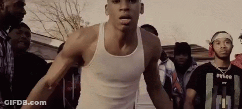 Man In White Tank Top Standing In Crowd GIF