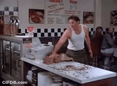 Man In White Tank Top Standing In Restaurant GIF