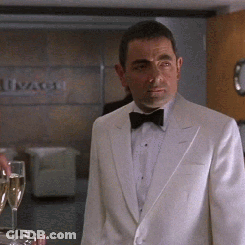Man In White Tuxedo And Bow Tie With Ivangard Sign GIF