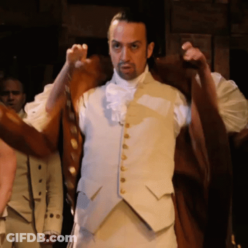 Man In White Vest With Gold Buttons In Dark Room GIF