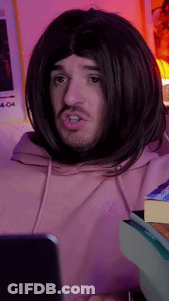 Man In Wig And Pink Hoodie Looking At Cell Phone GIF