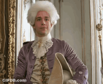 Man In Wig And Purple Jacket Holding Hat GIF