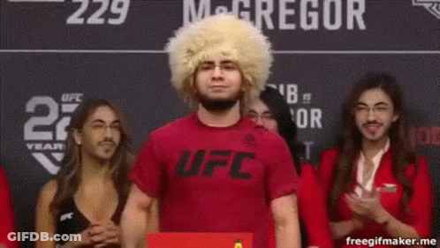 Man In Wig And Red Shirt In Front Of Crowd GIF