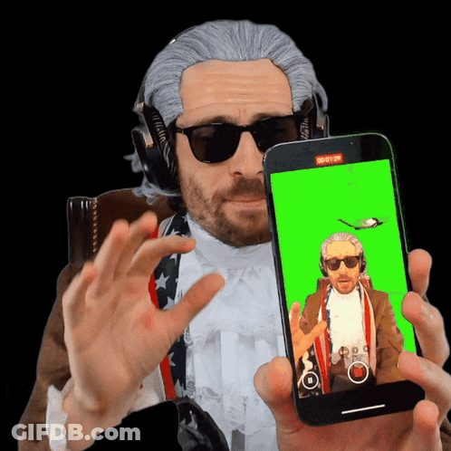 Man In Wig And Sunglasses Holding Cell Phone With Green Screen GIF