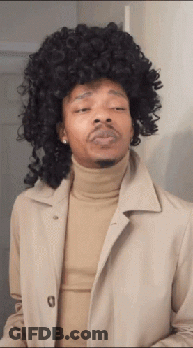 Man In Wig And Tan Trench Coat GIF