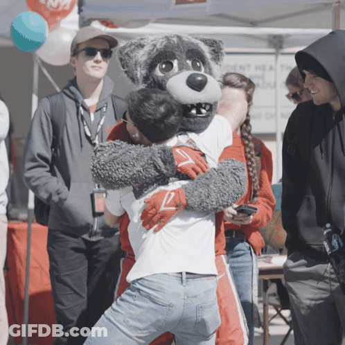 Man In Wolf Mascot Costume Hugs Another Man GIF