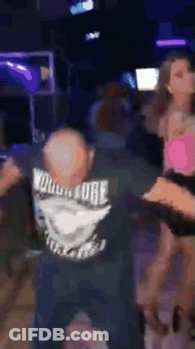 Man In Wolverine Shirt Dancing In Dark Room GIF