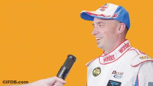 Man In Wonder Hat Being Interviewed GIF