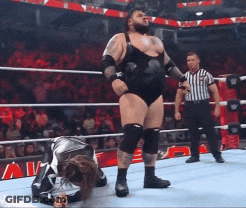 Man In Wrestling Ring With Referee And Sign Saying A GIF