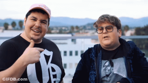 Man In Y T-Shirt Next To Man With Glasses GIF