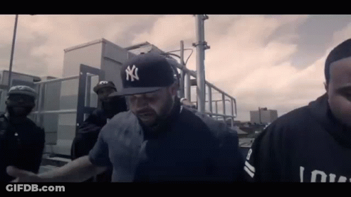 Man In Yankees Hat Led By Police Officer GIF