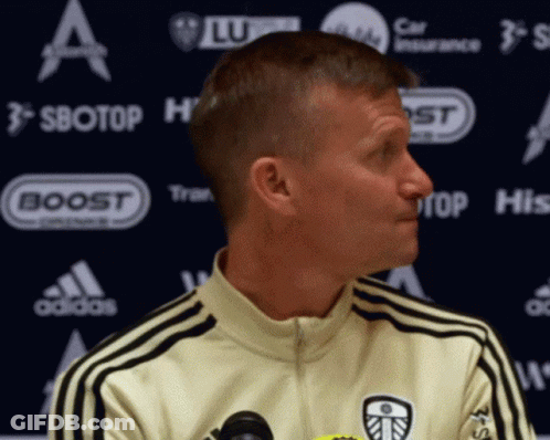Man In Yellow Adidas Jacket In Front Of Sbotop Banner GIF