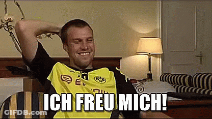 Man In Yellow And Black Shirt Sitting On Bed With Arms Over Head Ich Freu Mich GIF