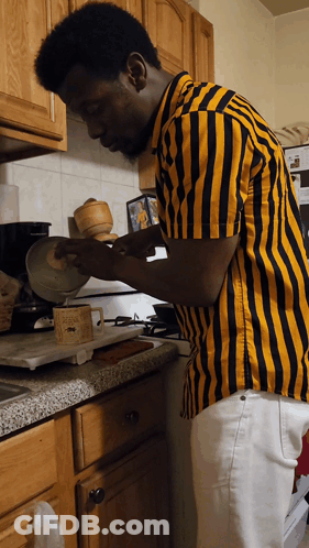Man In Yellow And Black Striped Shirt Cooking GIF