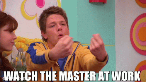Man In Yellow And Blue Jacket Says Watch The Master At Work To Woman GIF