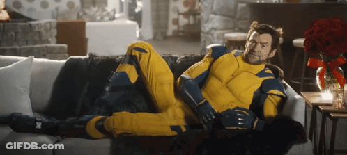 Man In Yellow And Blue Suit Laying On White Couch GIF