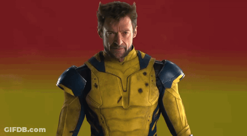 Man In Yellow And Blue Superhero Costume Holding Claws Out GIF