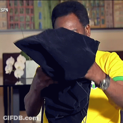 Man In Yellow And Green Shirt Covering Face GIF