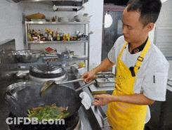 Man In Yellow Apron Cooking On Stove GIF