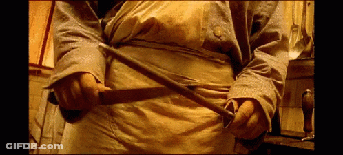 Man In Yellow Apron Holding Sword GIF