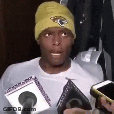 Man In Yellow Beanie Talking Into Microphone Holding Cell Phone GIF