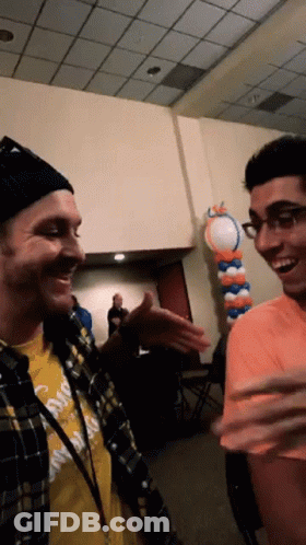 Man In Yellow 'California' Shirt Talking To Another GIF