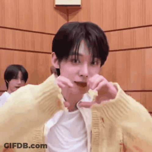 Man In Yellow Cardigan Making Heart Shape GIF