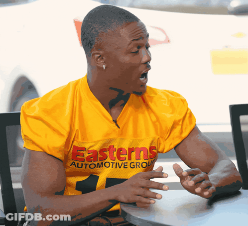Man In Yellow Easterns Automotive Group Jersey Sitting At Table GIF