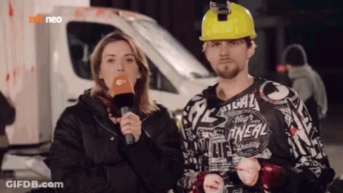Man In Yellow Hard Hat Next To Woman With Microphone GIF