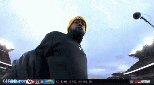Man In Yellow Hat At Microphone In Stadium GIF