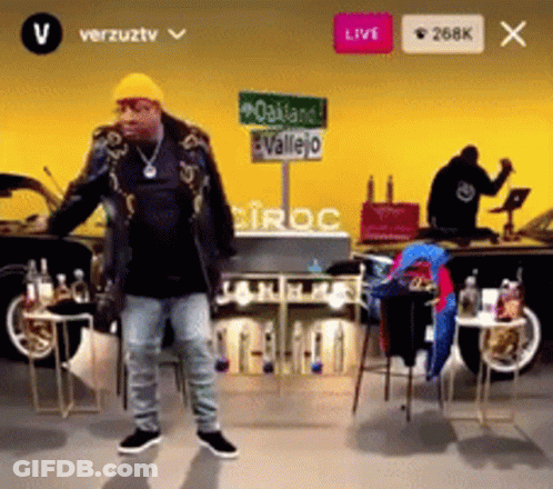 Man In Yellow Hat Dancing In Front Of Oakland Vallejo Sign GIF