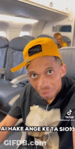 Man In Yellow Hat Sitting On Airplane GIF