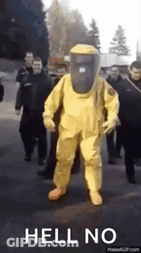 Man In Yellow Hazmat Suit Walking With Group GIF