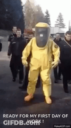 Man In Yellow Hazmat Suit Walking With Group GIF