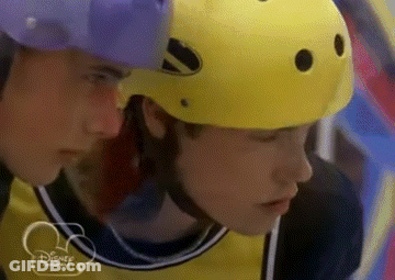 Man In Yellow Helmet Looking At Man In Purple Helmet GIF