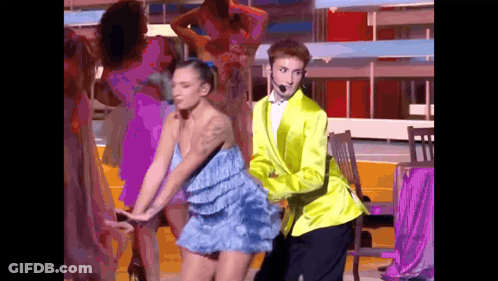 Man In Yellow Jacket Dancing With Woman In Blue Dress GIF