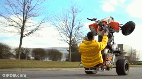 Man In Yellow Jacket Doing Trick On Four Wheeler Number 67 GIF