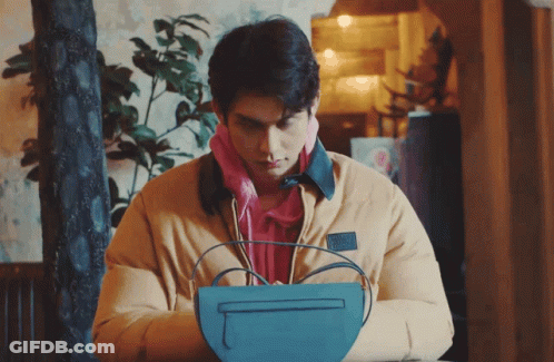 Man In Yellow Jacket Holding Blue Bag GIF