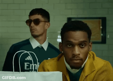 Man In Yellow Jacket Holding Paper Bag GIF