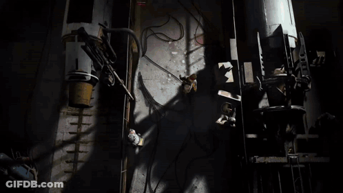 Man In Yellow Jacket In Dark Room With Light GIF