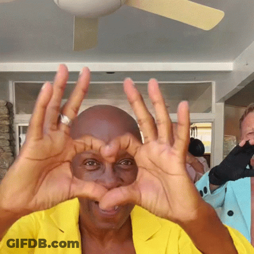 Man In Yellow Jacket Making Heart GIF