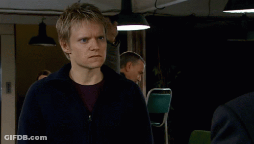 Man In Yellow Jacket Punched By Man In Brown Jacket GIF