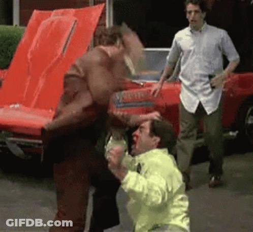 Man In Yellow Jacket Punched By Man In Brown Jacket GIF